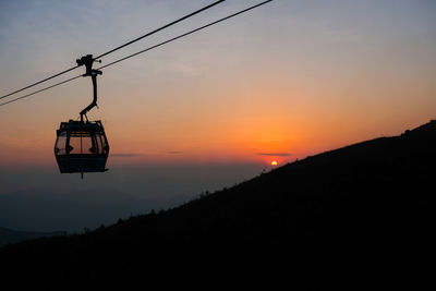 Overhead cable car against sky during sunset