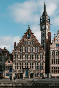 Buildings in city against cloudy sky