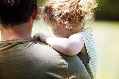 Close-up of father carrying daughter at park