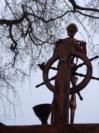 Low angle view of statue against bare trees