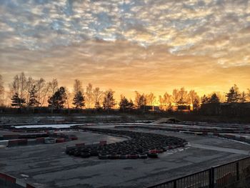 Cars on road against sky during sunset