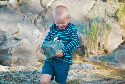 Full length of a boy holding rock