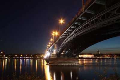 Illuminated heodor heuss bridge over rhine river at night