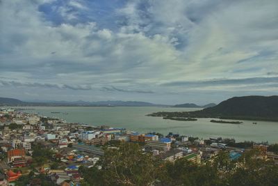 High angle view of city by sea against sky