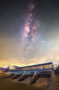 Bridge over river against sky at night
