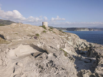 Rock formation on beach against sky