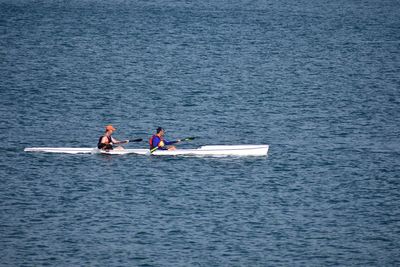 Men rowing on sea