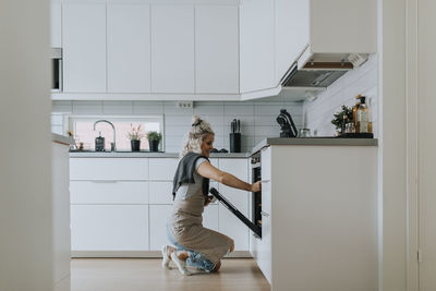 Woman standing in front of open oven