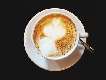 Close-up of cappuccino served on black background