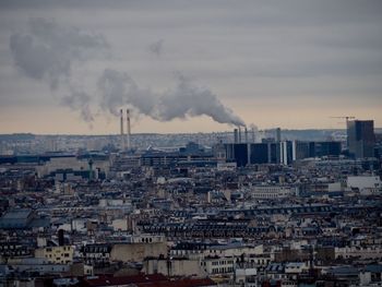 Smoke emitting from chimney against sky