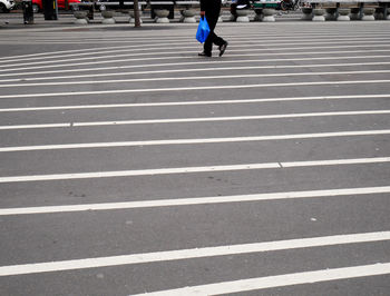 Low section of woman walking on zebra crossing