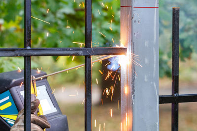 Sparks flame and arc of electric welding when welding a metal fence.