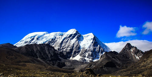 Scenic view of snowcapped mountains against blue sky