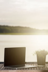 Close-up of coffee cup on table against sky