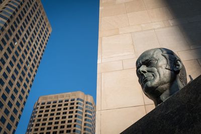 Low angle view of statue against buildings in city