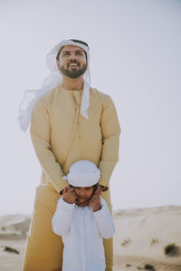 Portrait of smiling man standing on land against sky