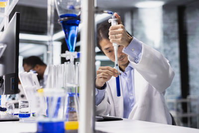 Female doctor examining chemical in laboratory