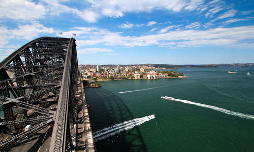 Sydney harbour bridge over sea against sky