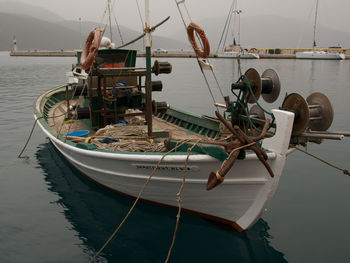 Fishing boats moored in sea against sky