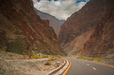 Scenic view of road by mountains against sky