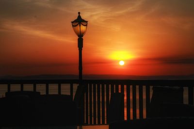 Silhouette of street light against sky at sunset