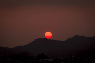 Scenic view of silhouette mountains against romantic sky at sunset