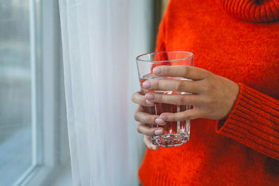 Midsection of woman holding wineglass