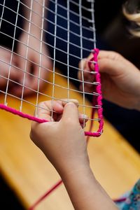 Cropped hands of person holding metal grate and thread