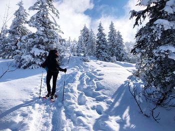 Rear view of woman standing on snow field