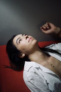 Portrait of young woman lying on bed at home