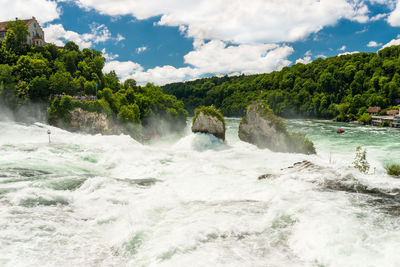 Beautiful, turquoise rhine river flowing from a waterfall in northern switzerland.