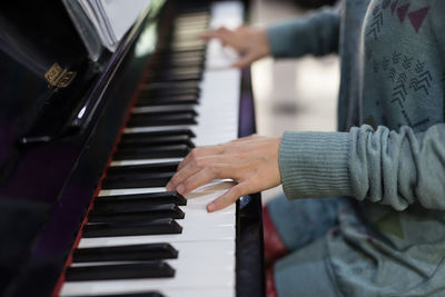 Midsection of man playing piano