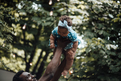 Father carrying daughter on shoulder outdoors