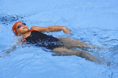 Elementary girl swimming in pool