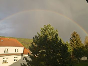 Rainbow over houses against sky