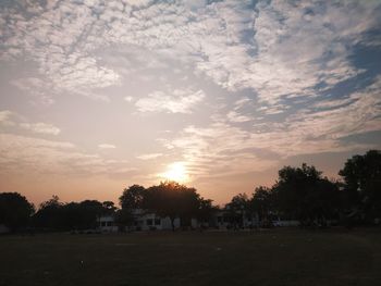 Silhouette trees on landscape against sky during sunset