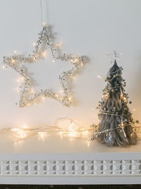 String lights with christmas trees and star decor on mantelpiece at home