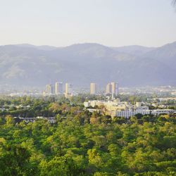 Scenic view of trees and buildings against sky