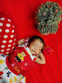 High angle view of cute baby girl sitting on bed