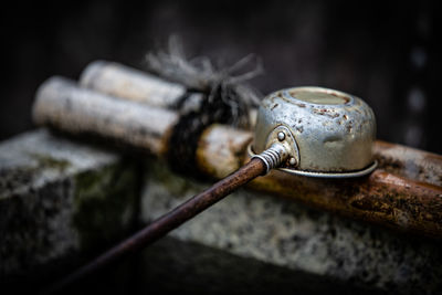 Close-up of rusty metal tied up on wood