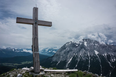 Cross on mountain against sky