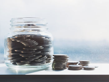 Close-up of glass jar on table against white background