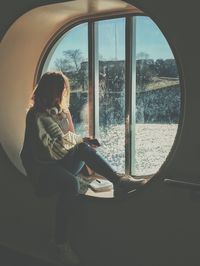 Woman looking through window