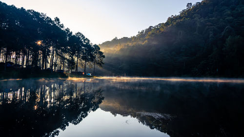 Reflection of trees in lake against sky