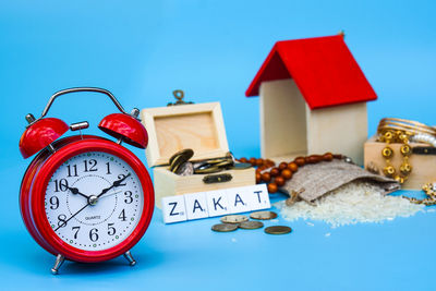 Close-up of clock on table against blue background