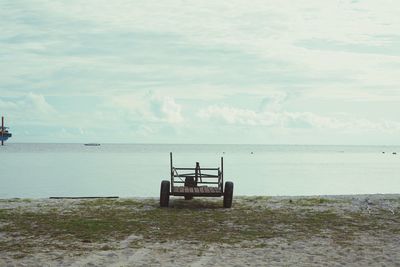 Chair on beach against sky
