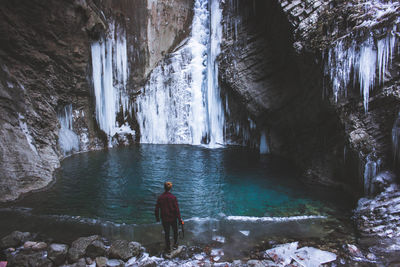 Rear view of man standing in cave