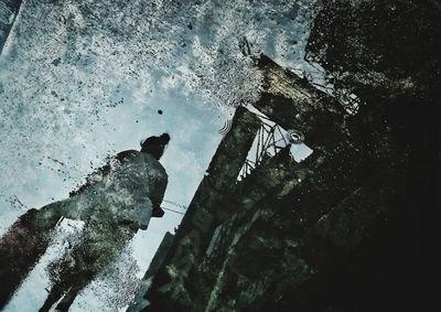 Reflection of man in puddle