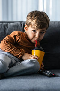 Boy sitting on sofa at home