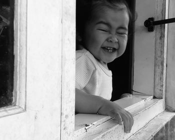 Portrait of girl sitting by door at home